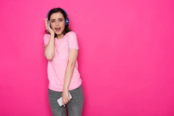 Ořezávaná fotka nádherné bruneta Kavkazská dívka se sluchátky na růžovém pozadí — Stock fotografie