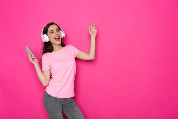 Foto recortada de menina branca morena sorridente usando fones de ouvido e dança — Fotografia de Stock