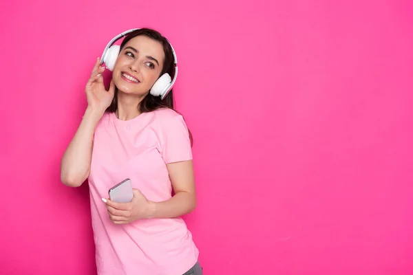 Foto recortada de una chica caucásica sonriente con auriculares y escuchando música — Foto de Stock