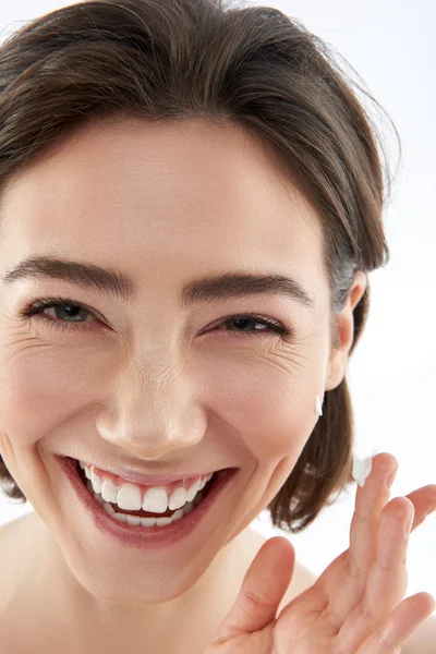 Mujer feliz con gota de crema en el dedo —  Fotos de Stock