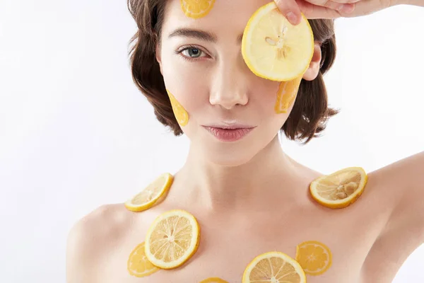 Young smiling woman with many lemon pieces — 스톡 사진