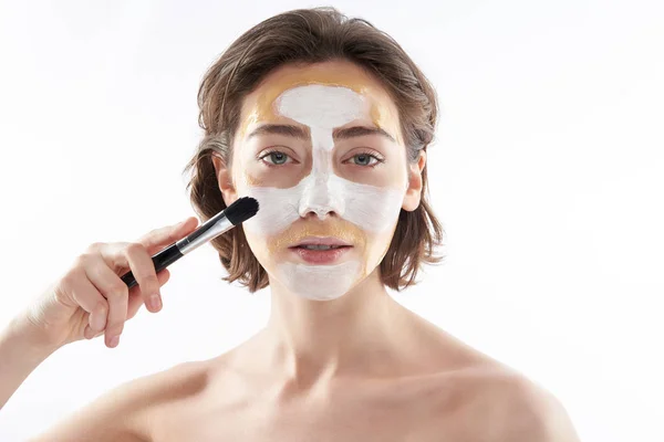 Wanita muda anggun dengan masker wajah dan kuas — Stok Foto