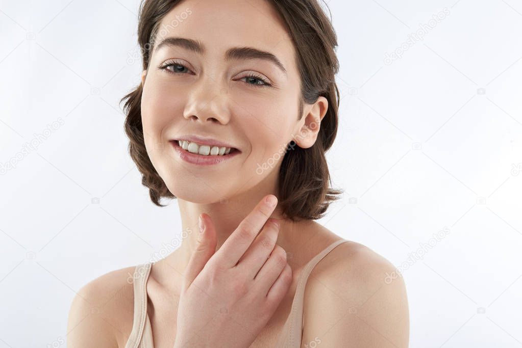 Young smiling tender brunette female on white