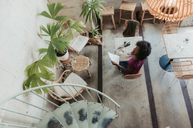 Kafeteryada kıvırcık saçlı Afrikalı kadının yüksek açısı