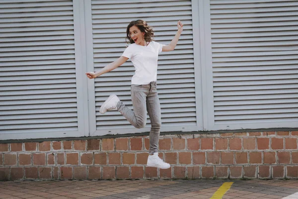 Happy young hipster girl jumping up on city view