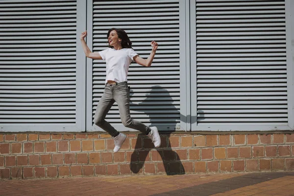 Счастливая юная брюнетка хипстер девушка прыгает вверх — стоковое фото