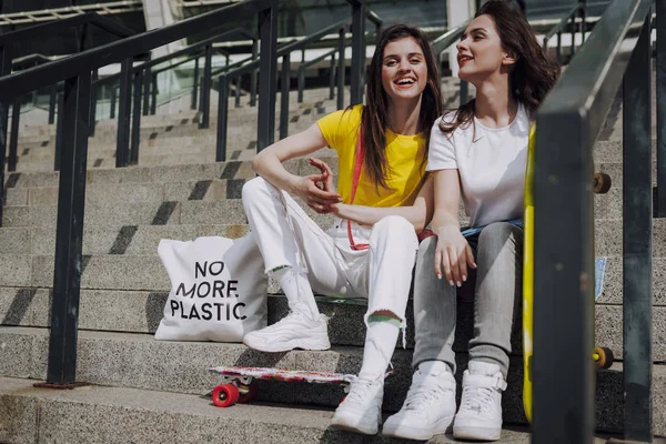 Dos niñas patinadoras felices sentadas en escaleras — Foto de Stock