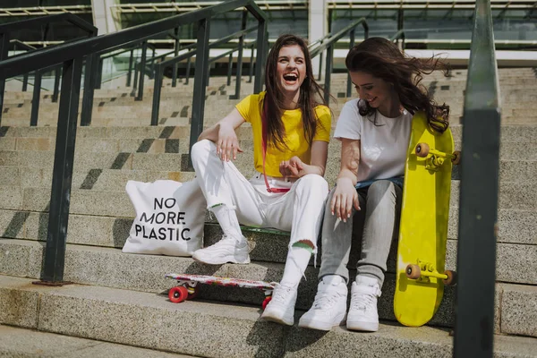 Dos chicas patinadoras riendo sentadas en escaleras — Foto de Stock