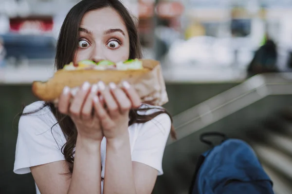 Aufgeregt überrascht Weibchen schaut auf großen Hot Dog — Stockfoto