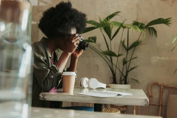Angolo basso di donna africana con i capelli ricci scattare foto in mensa — Foto Stock