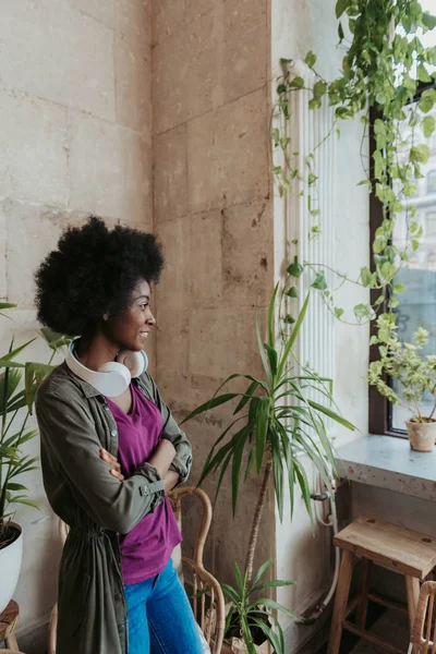 Felice donna africana con le cuffie sulle spalle incrociate e avendo riposo — Foto Stock