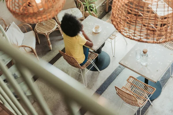 High angle of American girl sitting at table in cafeteria — Stock Photo, Image