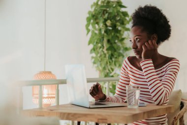 Kafede dizüstü bilgisayar üzerinde çalışan ciddi Afrikalı kadın yarım uzunlukta