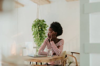 Kafede masada oturan sakin Afrikalı kadın yarım uzunlukta