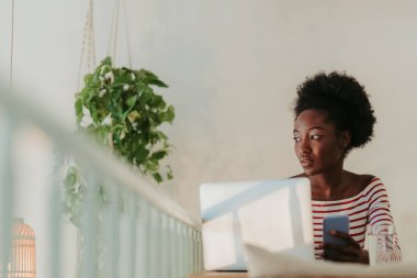 Kafede masada oturan Afrikalı kadın yarım uzunlukta
