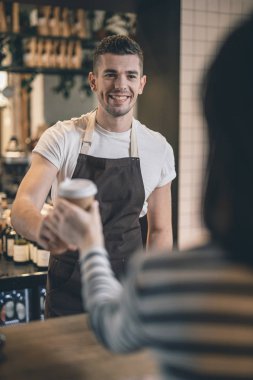 Kafe ziyaretçisine gülümseyen dost baristabel kadar