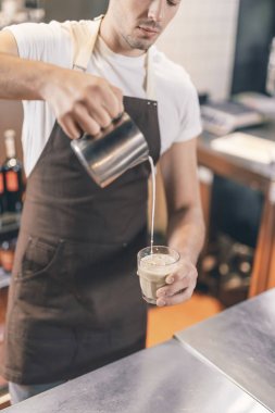 İş yerinde sütlü kahve yapan konsantre barista