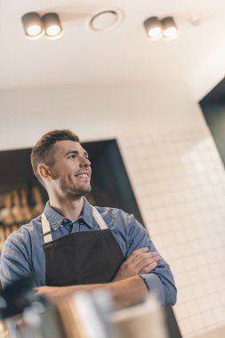 Neşeli barista mesafe içine bakarak ve gülümseyerek