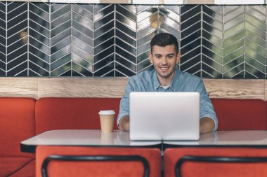 Masada oturan ve modern cihazı kullanan kendine güvenen kişi