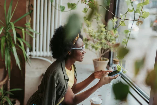 Alto angolo di felice signora africana guardando attraverso la finestra nel caffè — Foto Stock