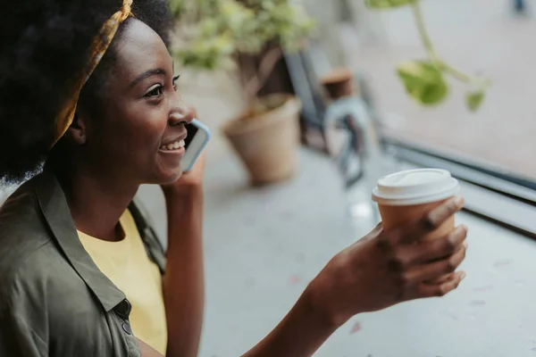 Nahaufnahme einer glücklichen afrikanischen Dame, die im Café Kaffee trinkt — Stockfoto