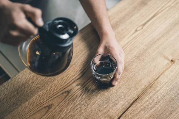 Mano tocando el vidrio mientras se vierte café en ella — Foto de Stock