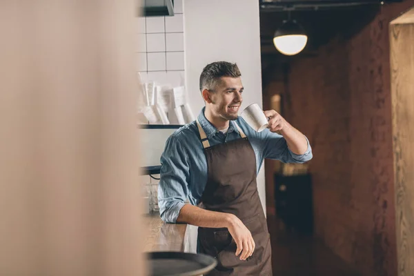 Serveur joyeux debout avec tasse et boire du thé — Photo