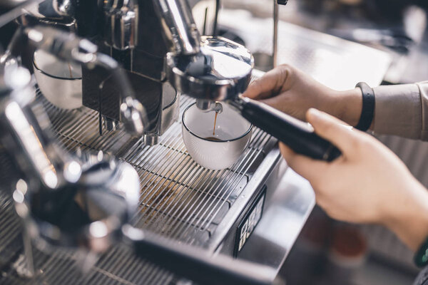 Close up of barista making coffee in espresso machine