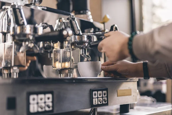 Mano de barista poniendo taza en la bandeja de la máquina de café espresso — Foto de Stock