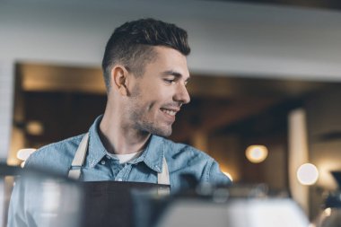 Tek başına işyerinde gülümseyen barista yakın
