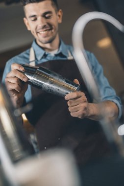 Kokteyl çalkalayıcının seçici odak noktası insanın elinde