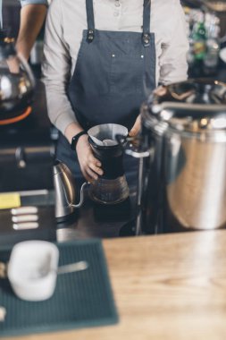 Barista nın elleri bar tezgahında kahvenin üzerine dökülüyor
