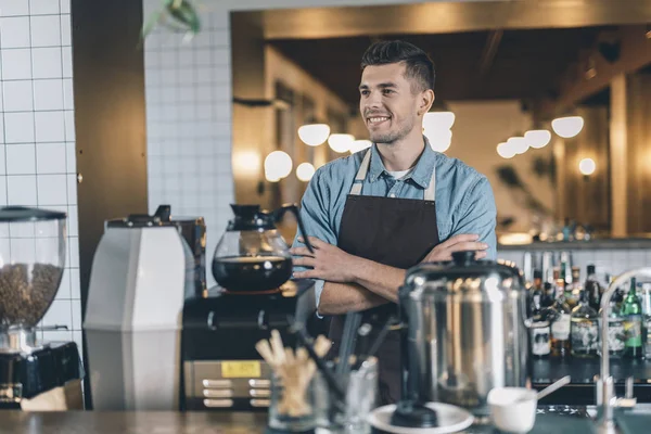 Barista sonriente sintiéndose bien y sonriendo mientras está solo —  Fotos de Stock