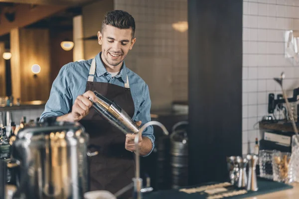 Barman positif regardant le shaker — Photo