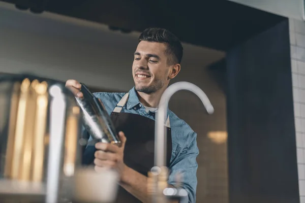 Happy young man making cocktails and smiling — Stock Photo, Image