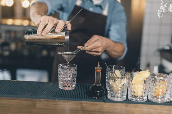 Ostrożny barman nalewanie koktajl przez sitko — Zdjęcie stockowe