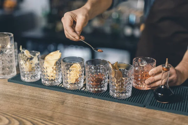 Szklanki przypraw i rąk Barista trzyma łyżkę herbaty — Zdjęcie stockowe