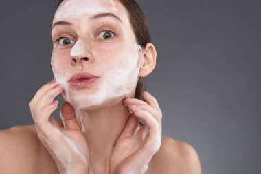 Çiller ile soapsuds ile yüzünü yıkama sevimli kız