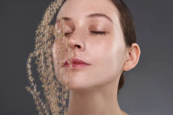 Mooie serene meisje met sproeten houden pluizig takje in de buurt van haar gezicht — Stockfoto