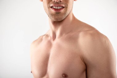 Gülümseyen genç adam kaslı göğsünü gösteriyor