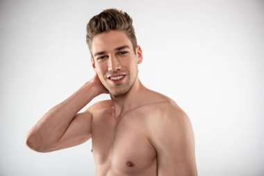 Başının arkasında el tutan mükemmel vücut ile yakışıklı genç adam