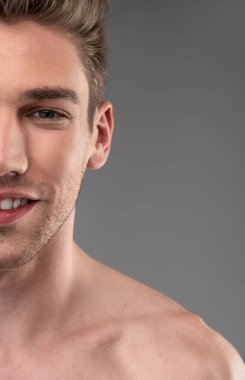 Yakışıklı genç adam mavi-gri arka plan karşı duran