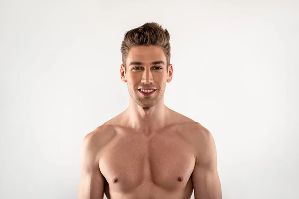 Aantrekkelijke jonge man met perfecte lichaam staande tegen witte achtergrond — Stockfoto