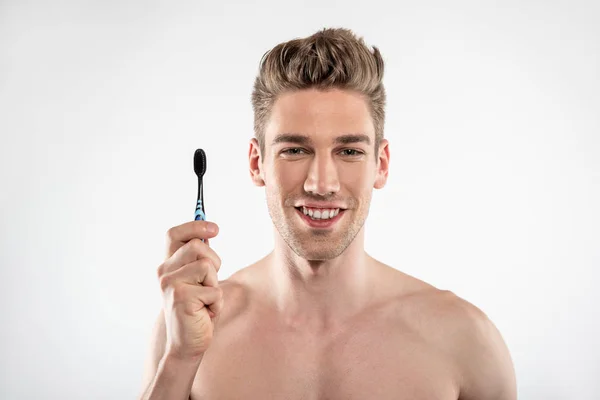 Χαρούμενος νέος άντρας με γένια κρατώντας οδοντόβουρτσα — Φωτογραφία Αρχείου