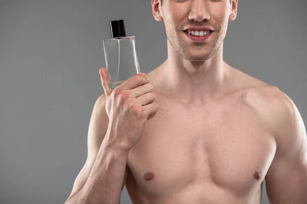 Jovem alegre com palha segurando garrafa de perfume — Fotografia de Stock