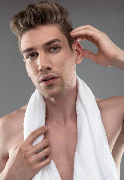 Όμορφος νέος άντρας με πετσέτα μπάνιου προσαρμόζοντας τα μαλλιά του — Φωτογραφία Αρχείου