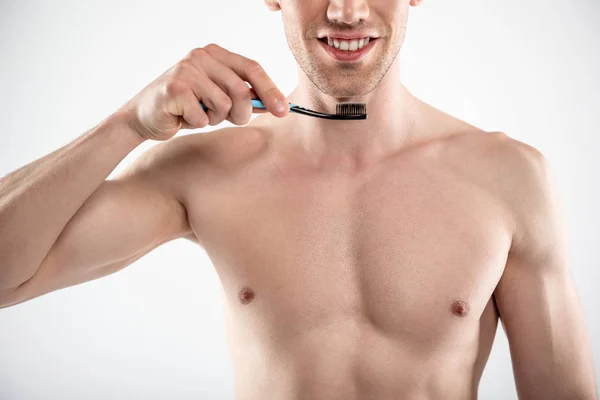 Naked young man with stubble holding toothbrush Stock Photo