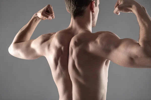 Strong athletic young man demonstrating his muscular body — Stock Photo, Image