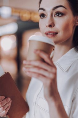 Rahat genç bayan havaalanında sıcak içecek tadını çıkarıyor