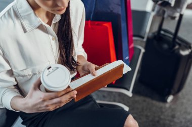 Kahveli kadın biniş kartıyla ilgili detayları okuyor